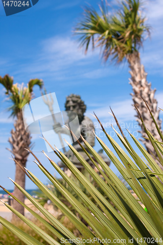 Image of King Neptune Statue and Tropical Foliage