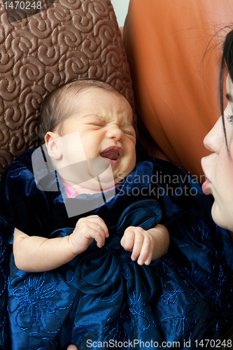 Image of Mother Comforts a Crying Newborn Baby