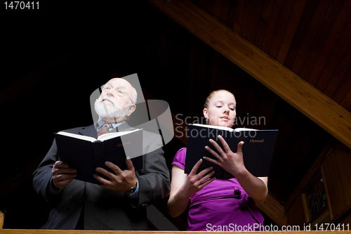 Image of Senior Caucasian Man Young Woman Standing Singing Holding Hymnal