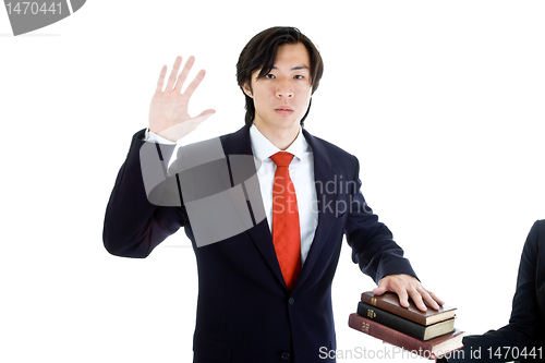 Image of Business Man Swearing Stack of Bibles, Isolated