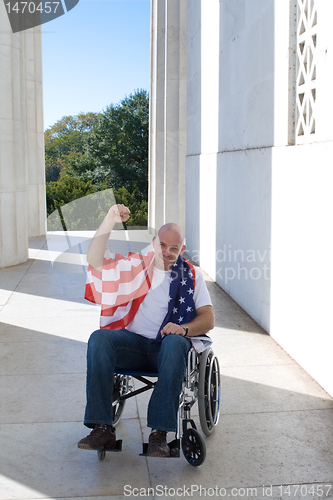 Image of Man Wheelchair American Flag Raised Fist Blue Sky