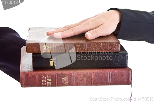 Image of Woman's Hand Stack of Bibles Isolated Background