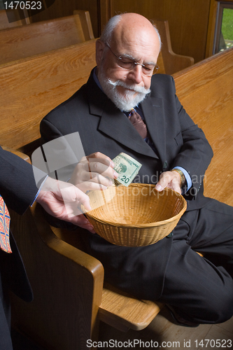 Image of Senior Man Putting Money into Church Basket