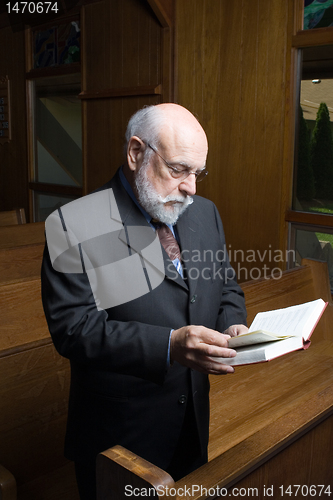 Image of Standing Senior Caucasian Man Reading Hymnal In Church Pew