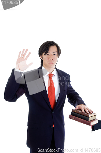 Image of Asian Man Swearing on a Stack of Bibles Isolated White