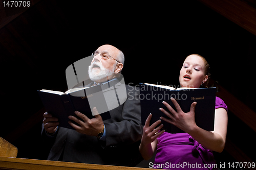 Image of Older White Man Young Woman Singing Church Hymnals