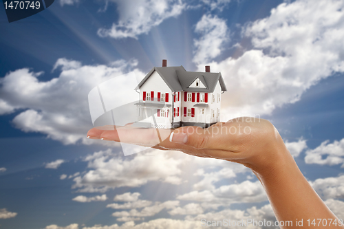Image of Model House in Female Hand on Sky Background