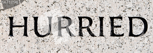 Image of Word "Hurried" Carved in Gray Granite Stone