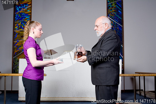Image of Senior Man Young Woman Holding Wine, Bread, Communion in Church 