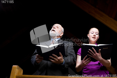 Image of Senior White Man Young Woman Singing in Church Holding Hymnals