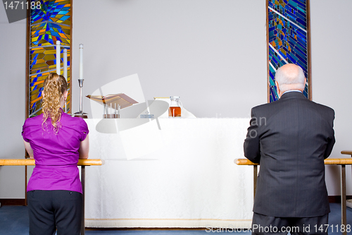 Image of Two Caucasian People Kneeling Taking Communion at Church Alter 