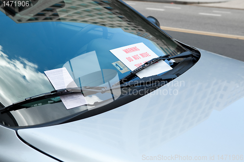 Image of Parking Ticket Under Windshield Wiper On Car, Warning Sign