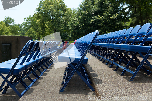 Image of XXXL Rows of Blue Red Metal Folding Chairs Outside