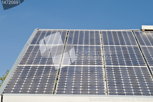 Image of Row of Solar Panels on Roof Against Blue Sky