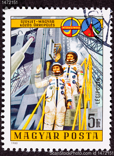 Image of Stamp Waving Astronauts Launch Tower Space Suit
