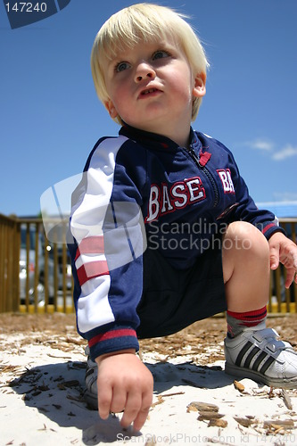 Image of Blonde boy playing in sandy playground