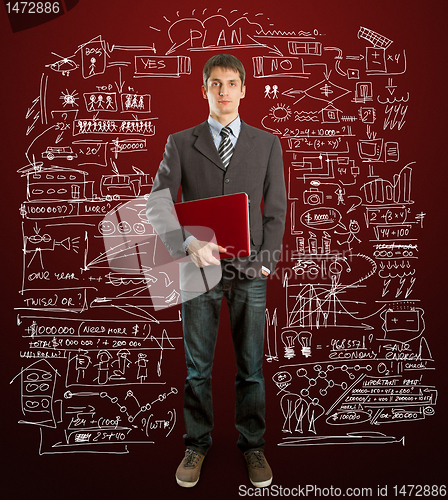 Image of male in suit with laptop in his hands