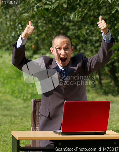 Image of man with red laptop working outdoors