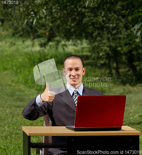 Image of man with red laptop working outdoors