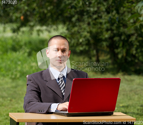 Image of man with laptop working outdoors