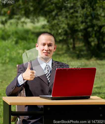 Image of man with laptop working outdoors