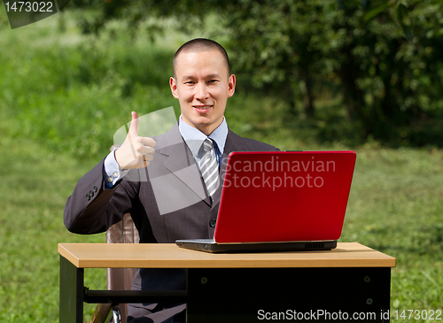 Image of man with laptop working outdoors
