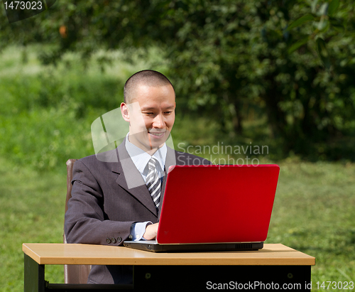 Image of man with laptop working outdoors