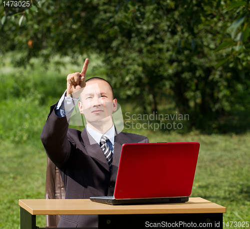 Image of man with laptop working outdoors