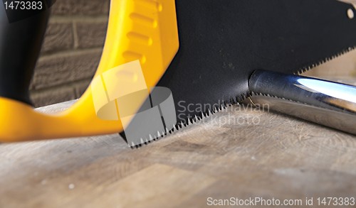 Image of Wooden saw used for cutting a metal pipe