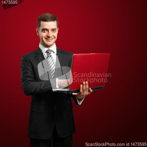 Image of male in suit with laptop in his hands
