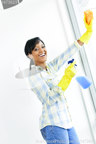 Image of Smiling woman cleaning windows