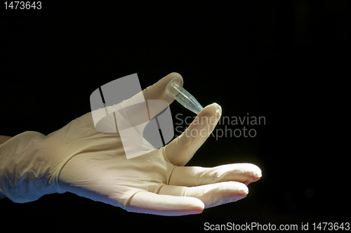 Image of Covered in white glove holding the tube