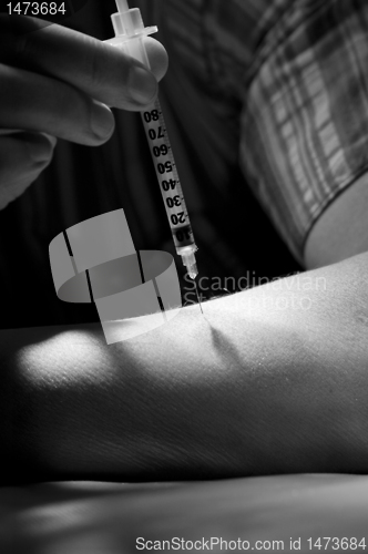 Image of Patient injects insulin pen at hand