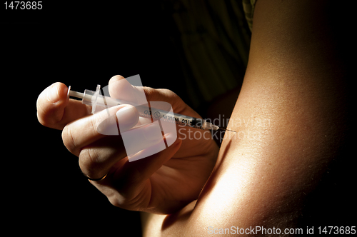 Image of Patient injects insulin pen at hand