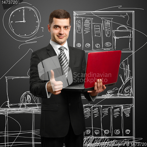 Image of male in suit with laptop in his hands