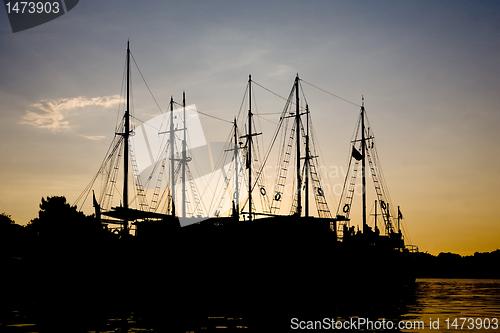 Image of sunset silhouettes of sailing vessels 