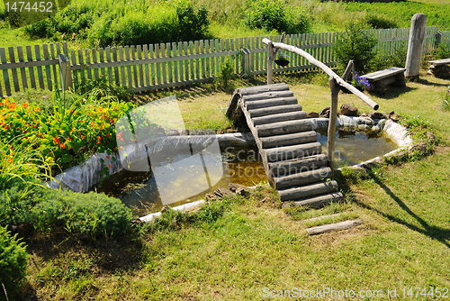 Image of small garden pond with wooden bridge