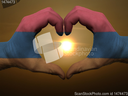 Image of Heart and love gesture by hands colored in armenia flag during b