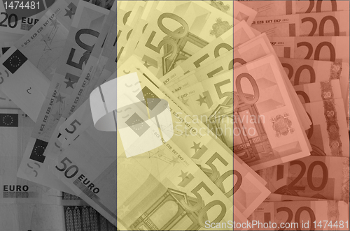 Image of flag of Belgium with transparent euro banknotes in background 