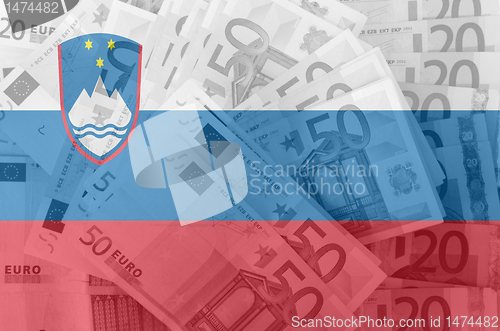 Image of flag of Slovenia with transparent euro banknotes in background 