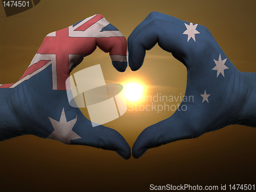 Image of Heart and love gesture by hands colored in australia flag during