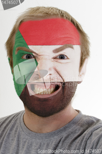 Image of Face of crazy angry man painted in colors of Sudan flag