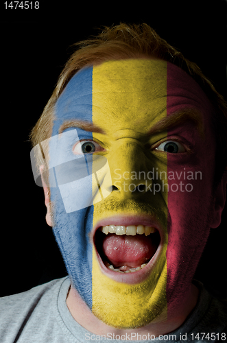 Image of Face of crazy angry man painted in colors of romania flag