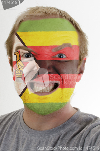 Image of Face of crazy angry man painted in colors of zimbabwe flag