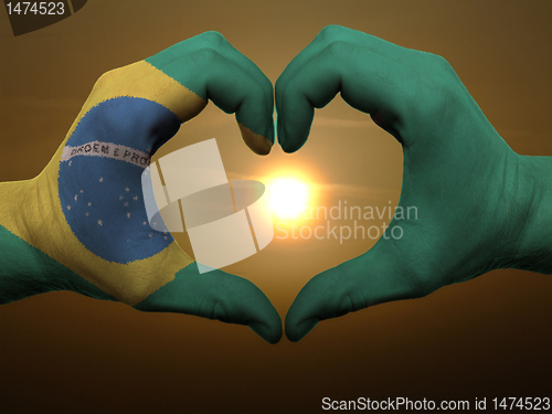 Image of Heart and love gesture by hands colored in brazil flag during be