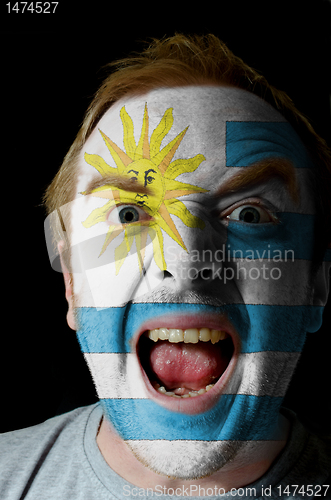 Image of Face of crazy angry man painted in colors of uruguay flag