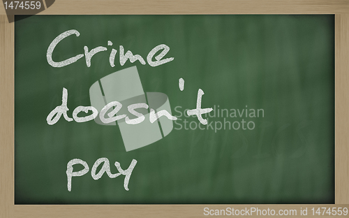 Image of " Crime doesn't pay " written on a blackboard