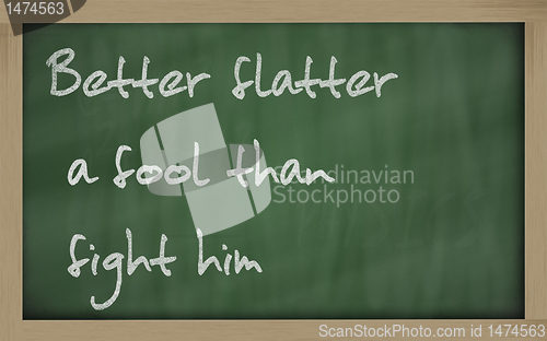 Image of "  Better flatter a fool than fight him " written on a blackboar