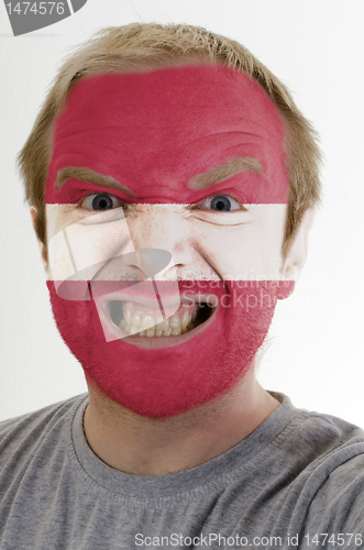 Image of Face of crazy angry man painted in colors of latvia flag
