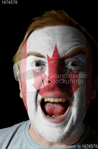 Image of Face of crazy angry man painted in colors of Brazil flag